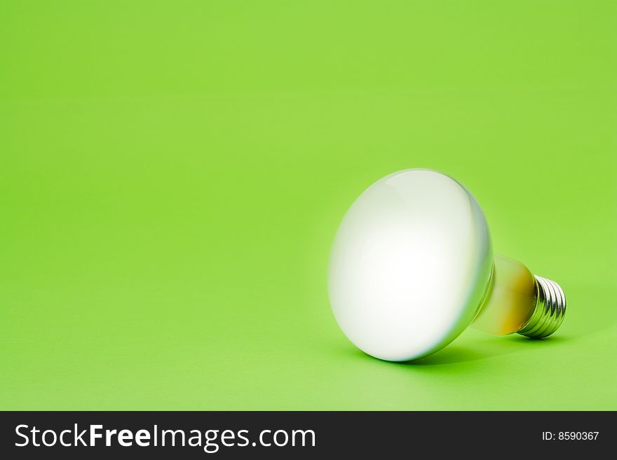 Light bulb spotlight on green background