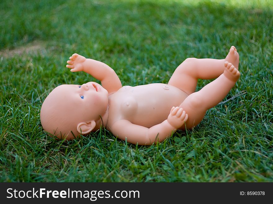 Abandoned doll in the grass