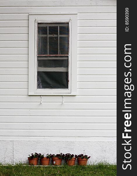 Window of a country bungalow with flower pots underneath. Window of a country bungalow with flower pots underneath