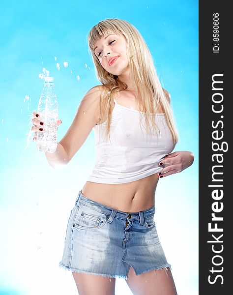 Beauty woman drink from bottle on blue background