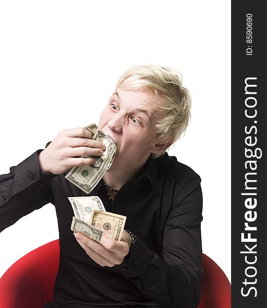 Boy eating money sitting in a chair