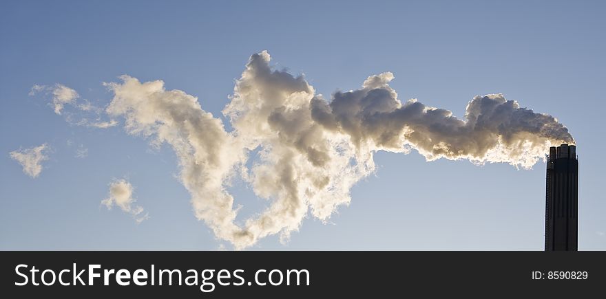 Smoking chimney against a blue sky