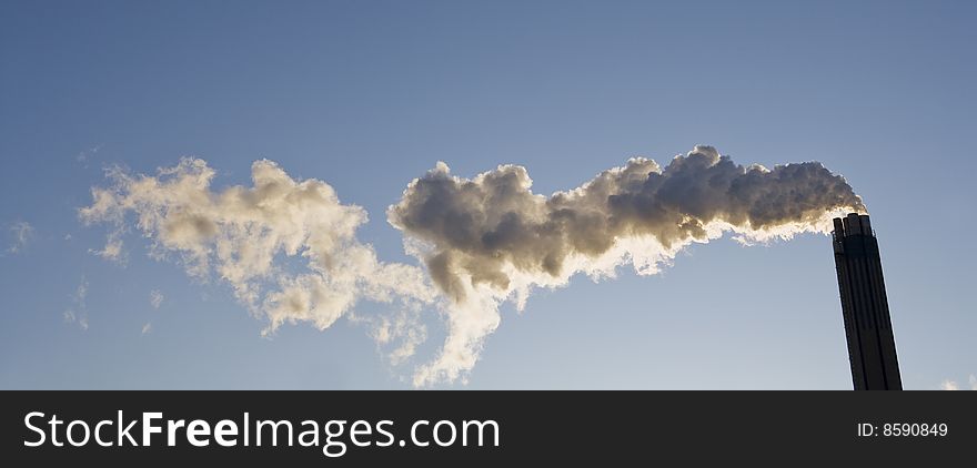 Smoking chimney against a blue sky