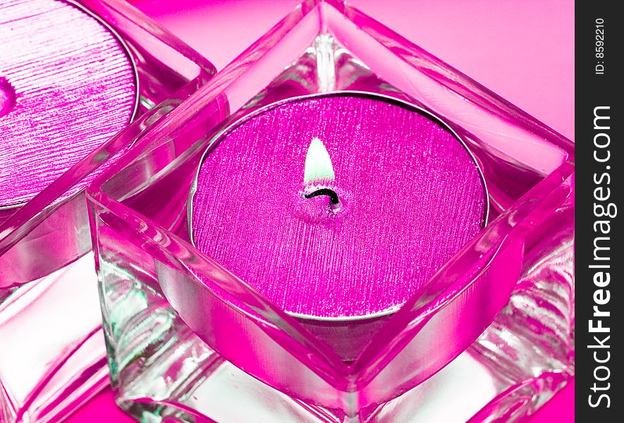 Pink candles in glass with water