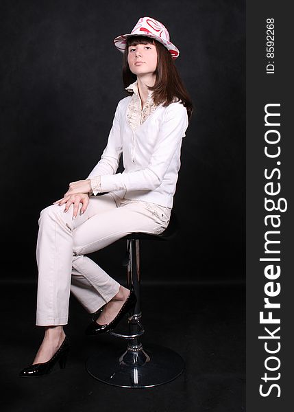 Smiling girl sitting on a chair in studio