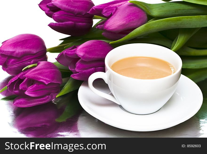 White cup of coffee with violet tulips