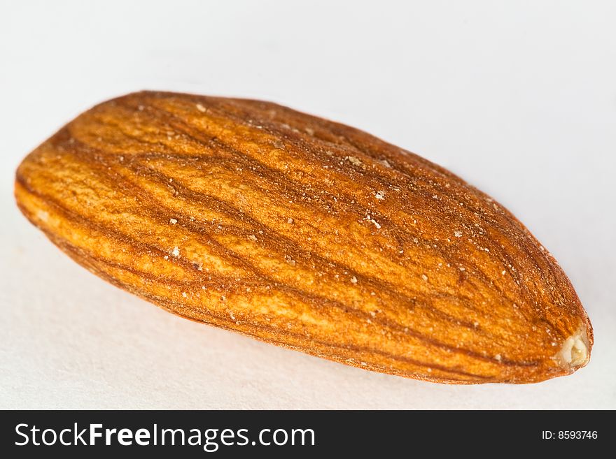 A macro shot of an almond nut against a white background