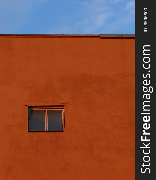 Single closed window on  background of  claret wall and  blue sky