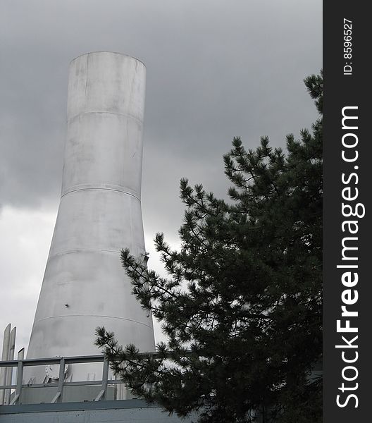 Large silver chimney and cloudy sky