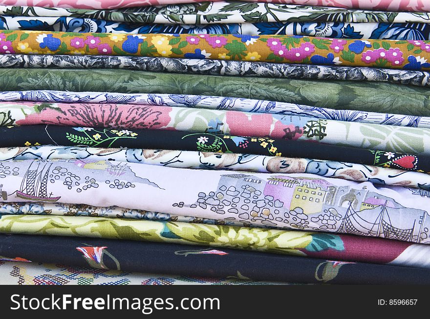 Side-view of a pile of colorfully printed textiles. Side-view of a pile of colorfully printed textiles