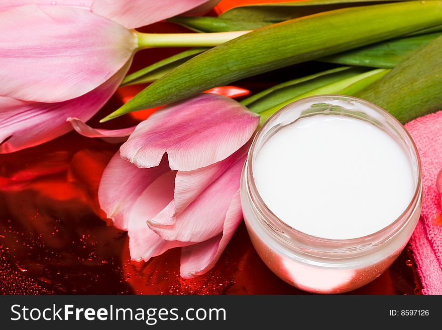 Cream, towel with flowers on red background