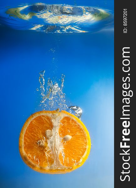 Orange in water on a blue background