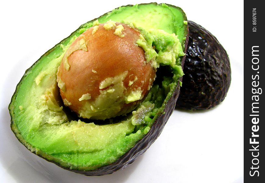 A cut open avocado on a white background
