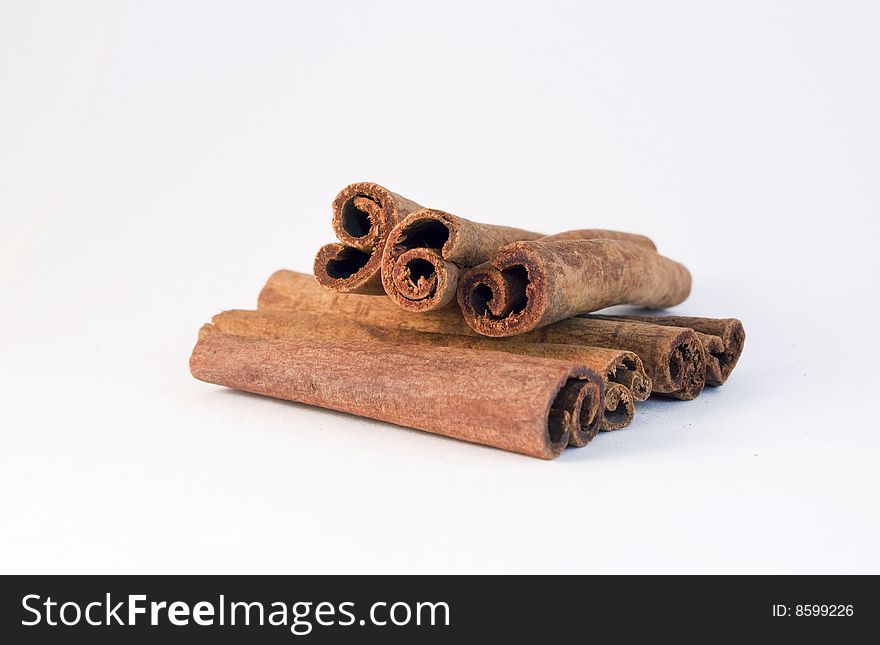 Cinnamon sticks stacked, against a white background.