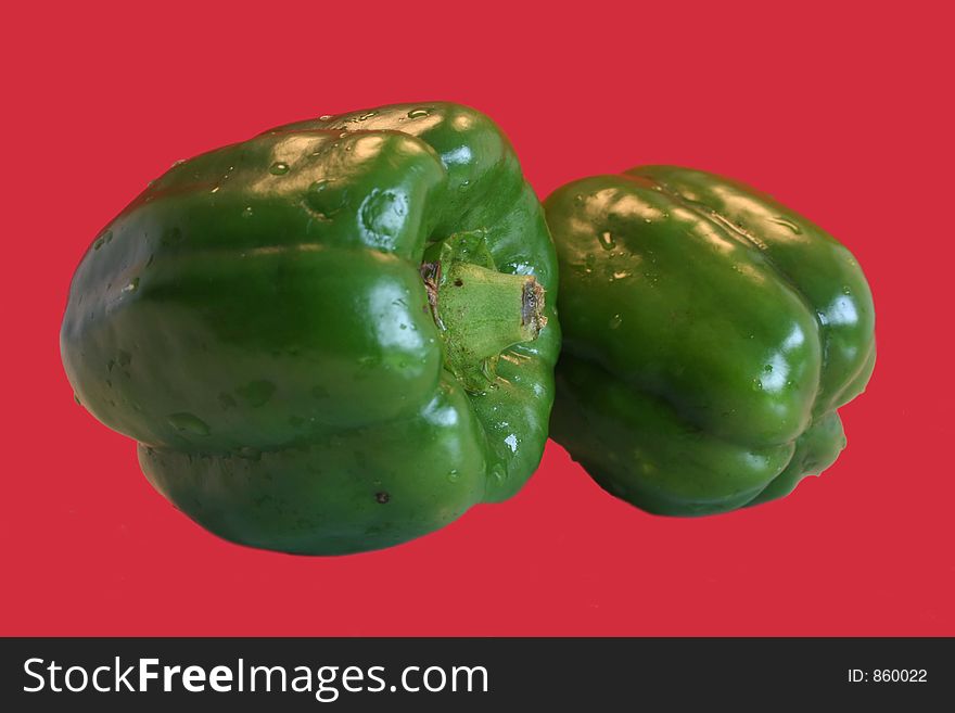 Green peppers isolated on a red background