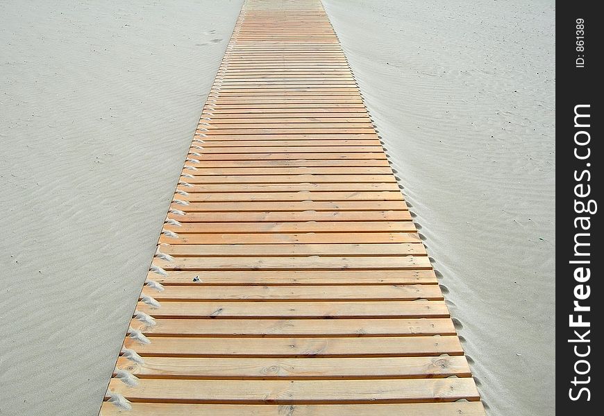 Wooden footbridge in the sand