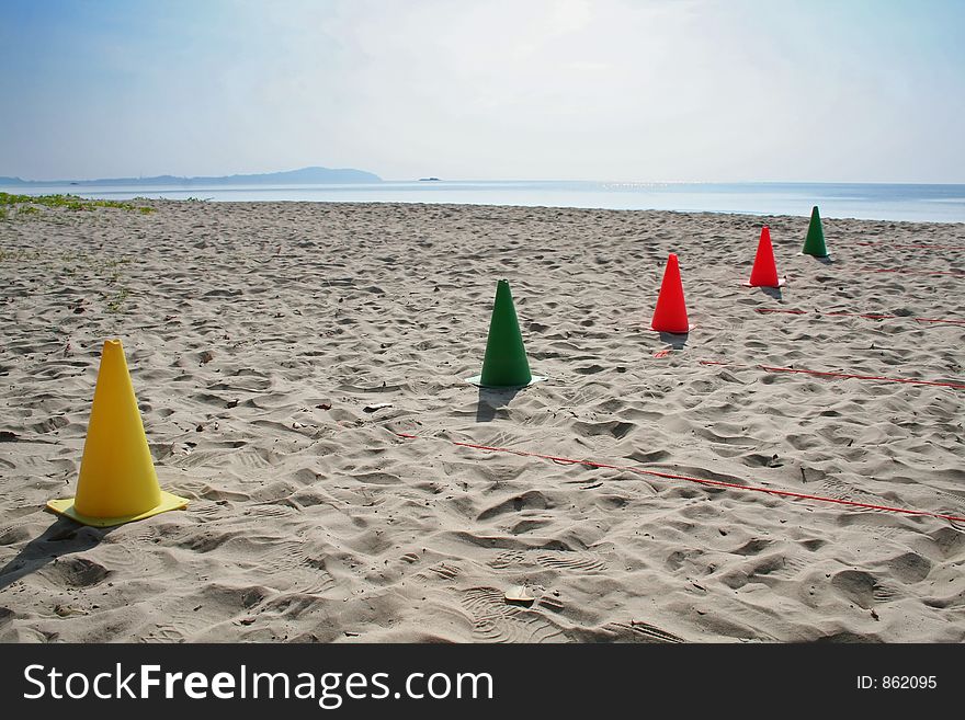 Multicolored cones on the beach, arranged for sports activities