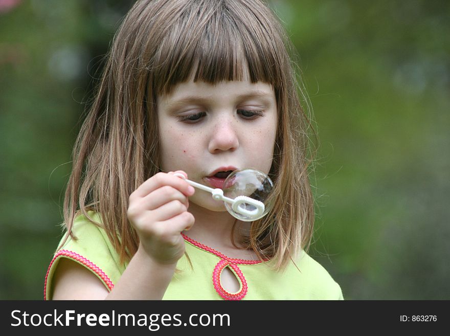 Girl blowing bubbles on bubble wand. Girl blowing bubbles on bubble wand