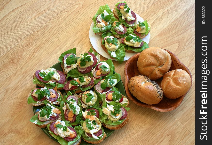 Just made sandwiches put together with fresh breadroll on the table in kitchen. Just made sandwiches put together with fresh breadroll on the table in kitchen