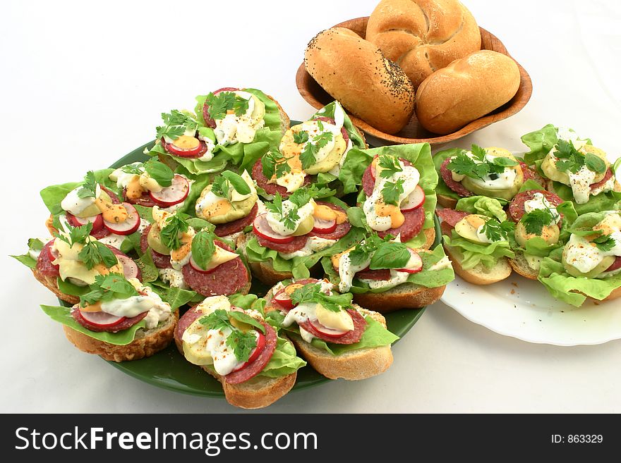 Fresh springtime sandwiches put together on plates next to breadrolls. Fresh springtime sandwiches put together on plates next to breadrolls