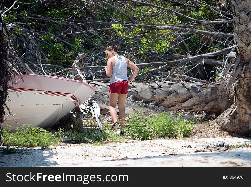 Young girl checks out boat destroyed by hurricane and abandoned. Young girl checks out boat destroyed by hurricane and abandoned