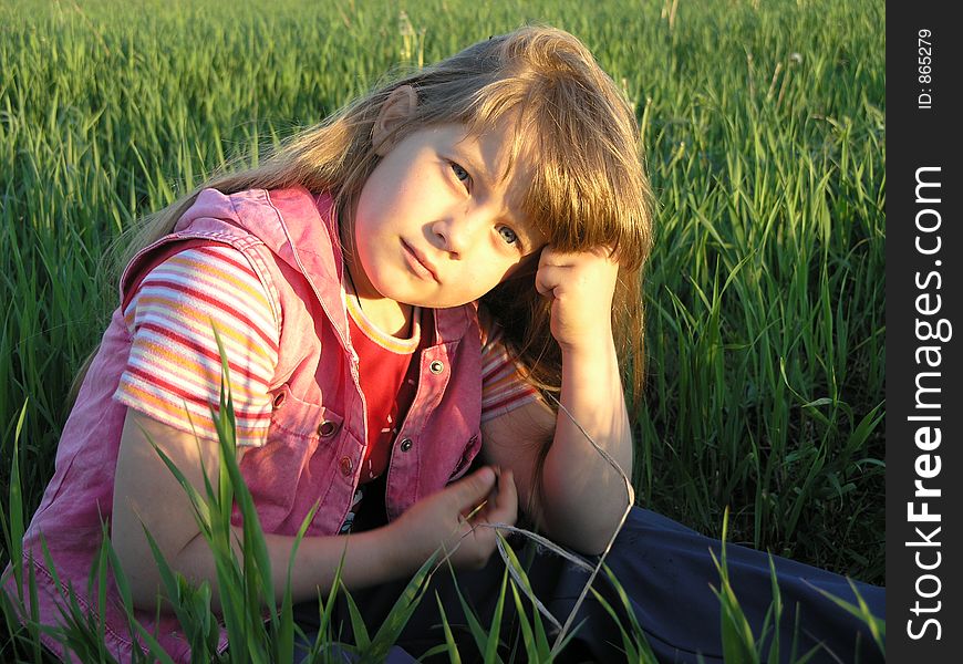 Sadly babygirl sitting in a green grass. Sadly babygirl sitting in a green grass