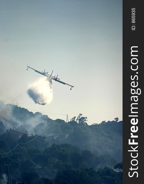 Fire in the corsican mountains: a plane is throwing water on the fire