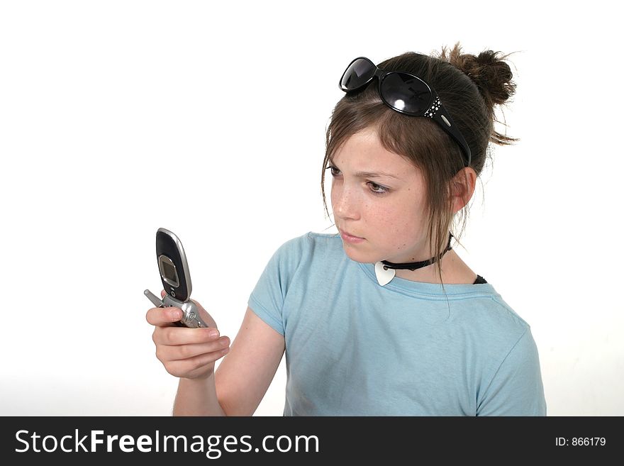 Cute tween or young teenage girl wearing sunglasses on top of her head, standing, and talking on a cellphone; shot on white. Cute tween or young teenage girl wearing sunglasses on top of her head, standing, and talking on a cellphone; shot on white
