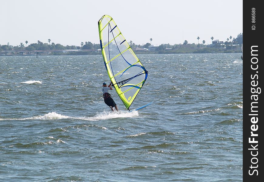 This wind surfer moves really fast accross the water propelled by the warm Florida winds in the Indian River near Port Canaveral, FL. This wind surfer moves really fast accross the water propelled by the warm Florida winds in the Indian River near Port Canaveral, FL.