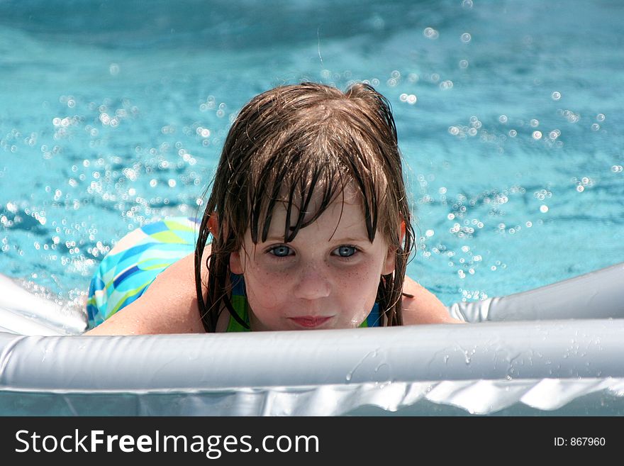 Girl in swimming pool on raft