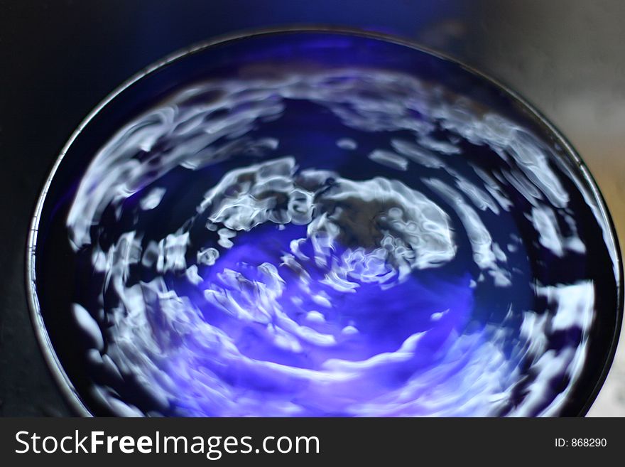 Close-up of water drop into blue bowl. Close-up of water drop into blue bowl.