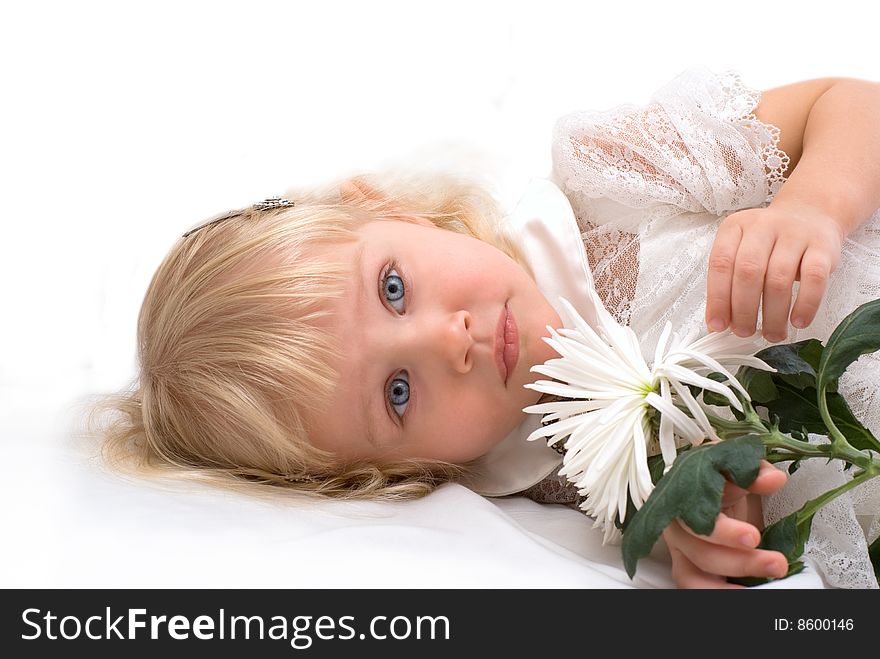Beautiful girl lies on a white flower in his hand