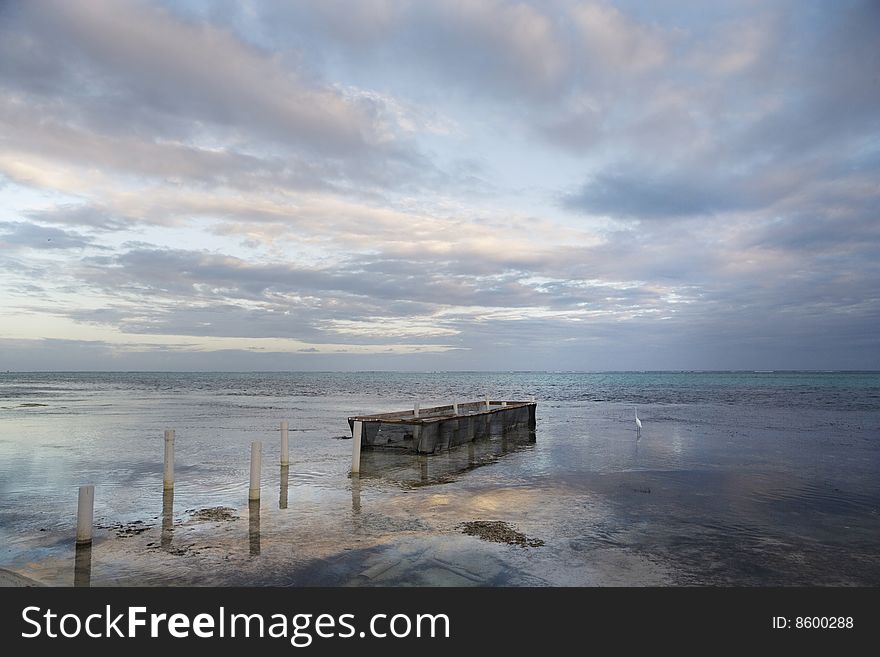 A lone egret and fish-holding pen at sunset along the shore of Ambergris Caye in Belize. A lone egret and fish-holding pen at sunset along the shore of Ambergris Caye in Belize.