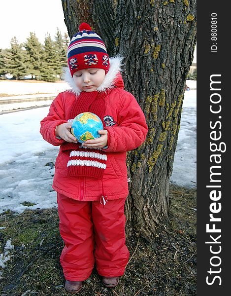 Little girl with a terrestrial globe in park near tree. Little girl with a terrestrial globe in park near tree