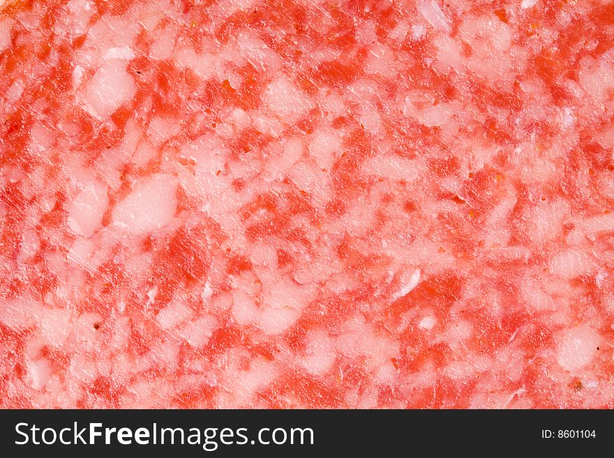 A close-up of the texture of a slice of salami. A close-up of the texture of a slice of salami