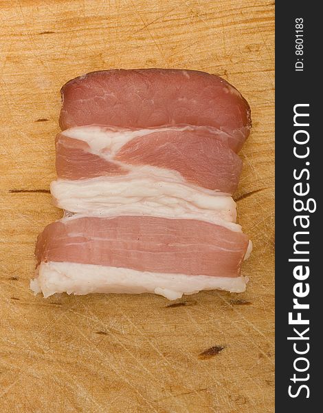 Bit of bacon on kitchen chopping board. Bit of bacon on kitchen chopping board