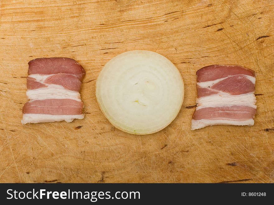 Bacon and onion on kitchen chopping board