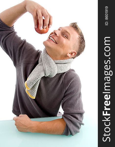 Smiling young man going to eat apple against white background