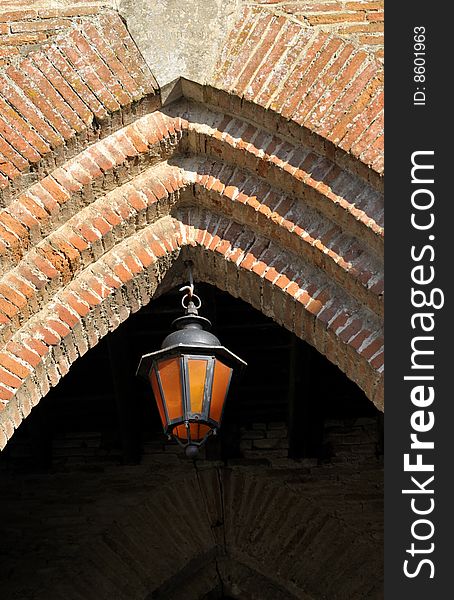 A lamp hanging in the bricks arch
