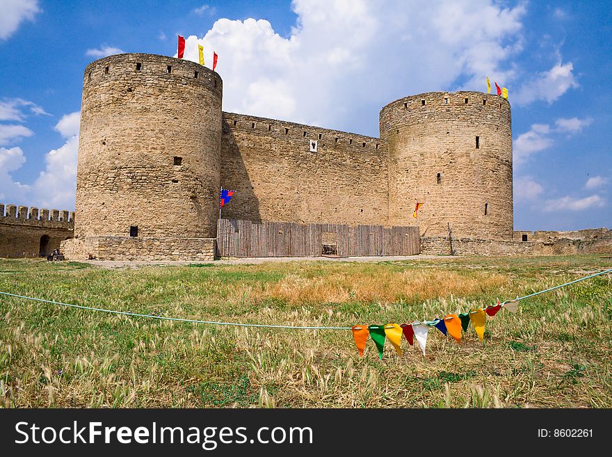 Old stone fortress with towers against blue sky. Old stone fortress with towers against blue sky