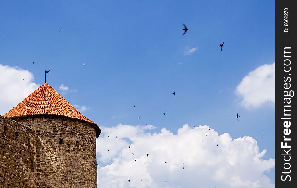 Old stone fortress tower against blue sky. Old stone fortress tower against blue sky