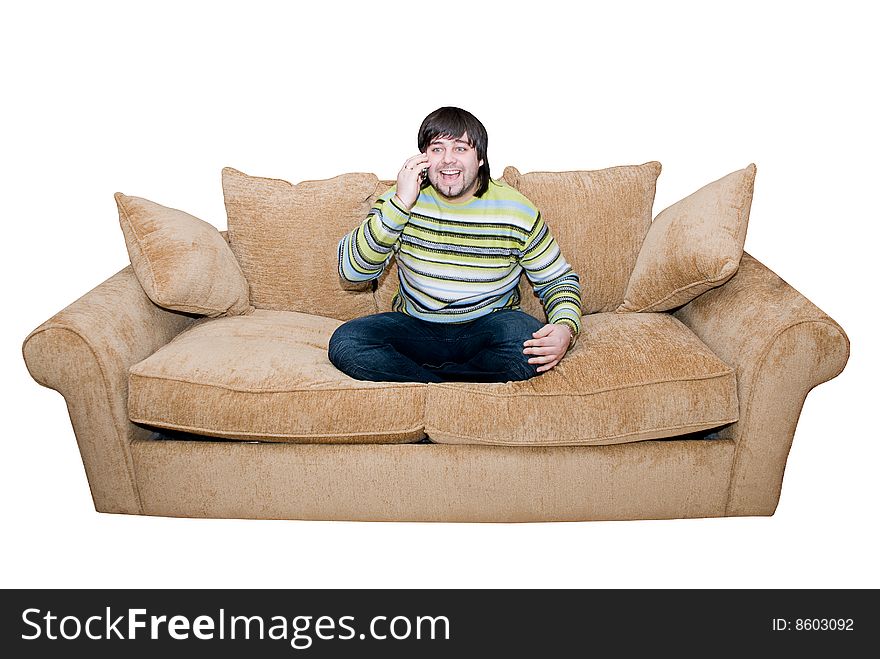 Happy young man talking and smiling on the cell phone sitting on the sofa. Happy young man talking and smiling on the cell phone sitting on the sofa