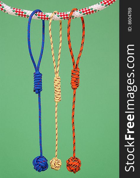 Colorful strings are hanged on another string on green background