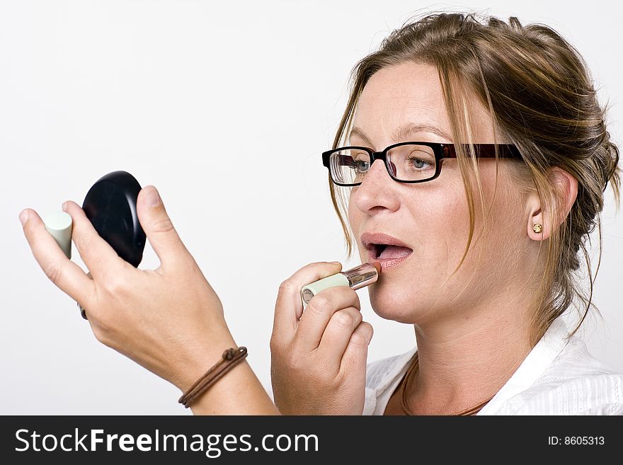 Modern woman putting on lipstick. Modern woman putting on lipstick