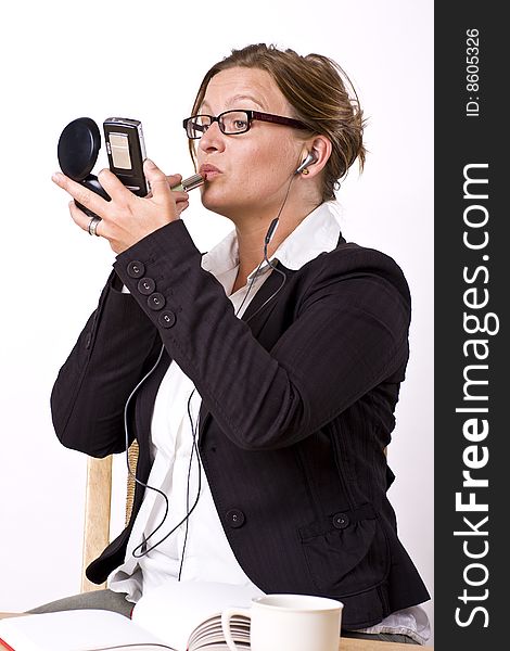 Busy businesswoman putting on make-up and talking in phone