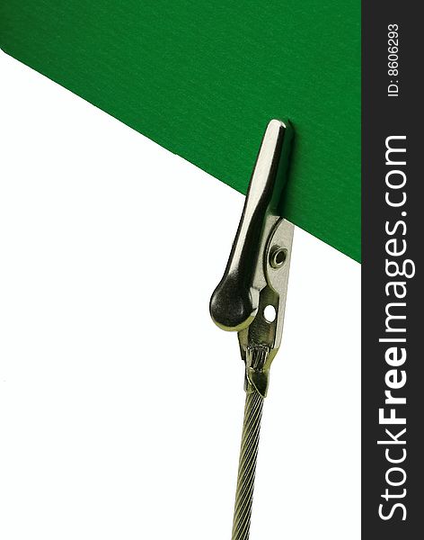 Metal clip holding a green card