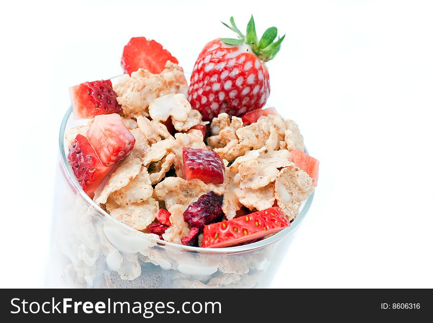 Bowl with corn flakes and strawberry served on glass