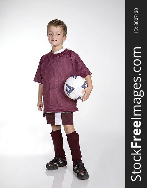 A boy poses with a soccer ball. A boy poses with a soccer ball