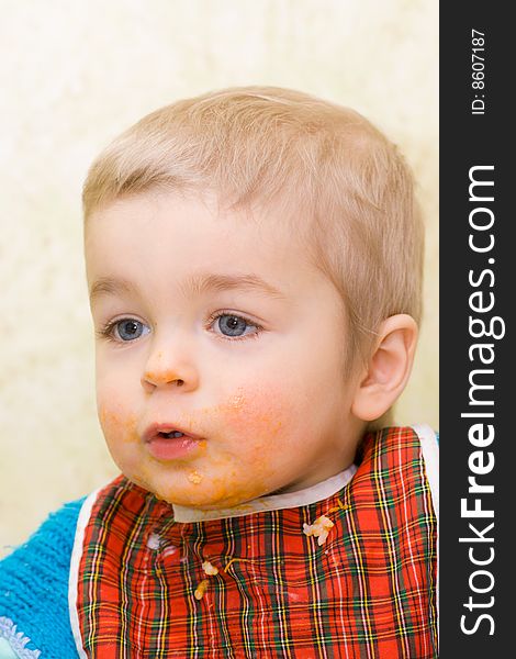 Cute little boy stained with squash, home interior