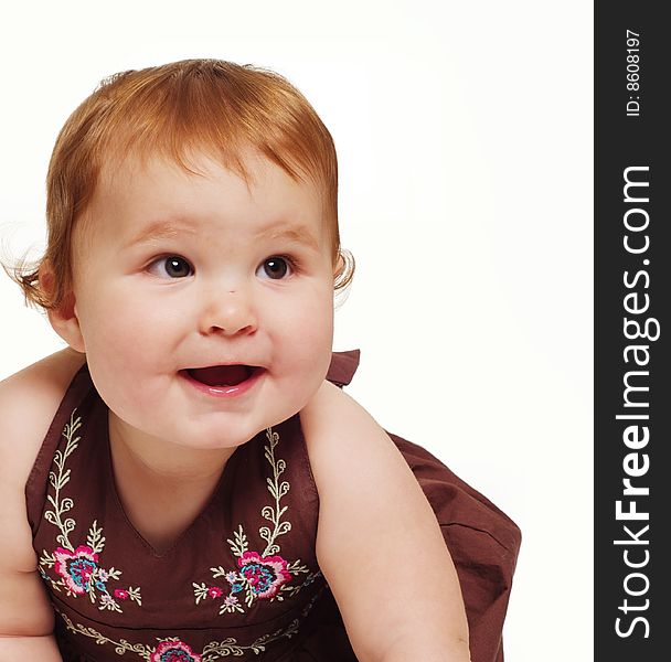 Adorable little baby wearing brown dress holding toy isolated against white background